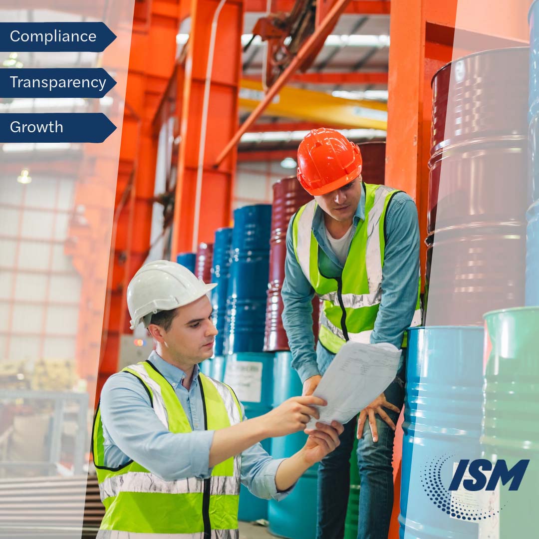 two men reviewing data next to barrels of resin