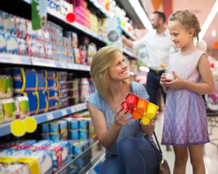 A stock color photo of a mother and daughter in a typical grocery dairy aisle representing how dairy packaging shelf appeal and brand reputation matter.
