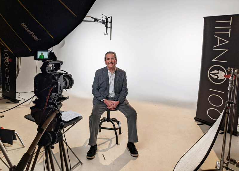 James Davis, ISM’s CEO and President shown in the Titan 100 program studio conducting an interview in front of a camera.  